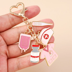 Nurse themed gold keychain with pink medical charms like thermometer and nurse hat