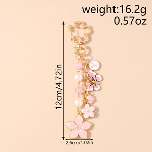 Detailed macro view of cherry blossom keychain with butterfly pendant and pearl beads