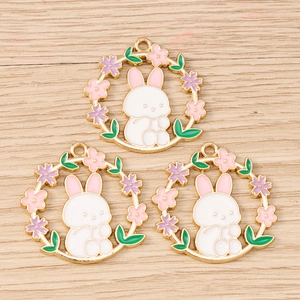 Detail of floral rabbit wreath charms with white enamel and golden plating for DIY jewelry