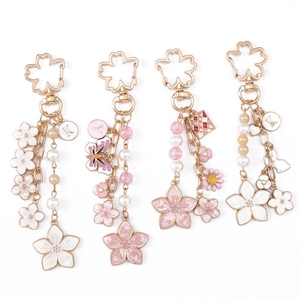 Elegant cherry blossom keychains with gold metal accents, faux pearls and butterfly charms