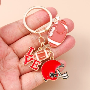 Detail of a golden American football keychain with red helmet and LOVE charm