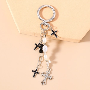 Detail of gothic keychain with black crosses, pearls, and a silver rhinestone cross charm
