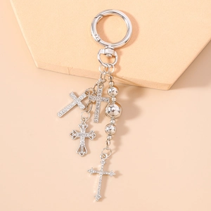 Detail of silver cross keychain featuring four rhinestone pendants and beaded chain links