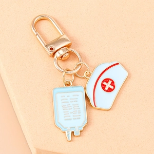 Detailed close-up of nurse hat and blue IV bag pendants on a gold medical keychain
