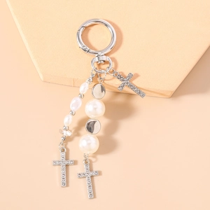 Close-up of pearl beaded keychain with sparkling rhinestone cross charms and metal ring