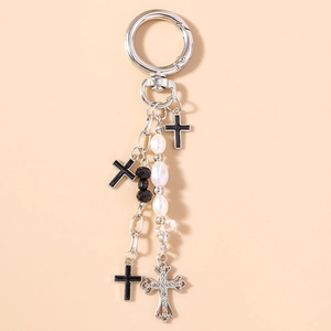 Detailed macro view of gothic cross keychain with white pearls and black beads