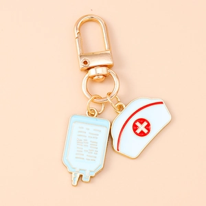 Detailed view of nurse hat and IV drip enamel charms on a golden metal keychain