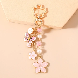 Close-up of pink cherry blossom keychain with butterfly pendant and pearl chain details