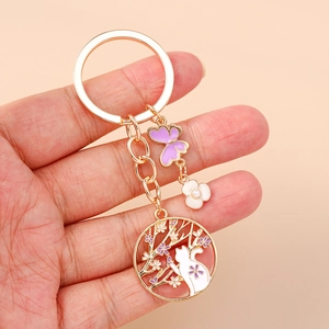 Dettaglio portachiavi gatto fiori di ciliegio con finiture oro e smalto viola