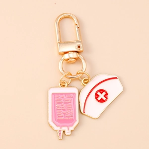 Detail of medical keychain showing pink infusion bag and white nurse hat with red cross logo