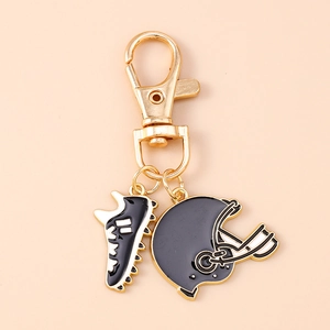 Macro detail of football helmet and shoe charms on a golden lobster clasp keychain