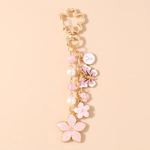 Close-up of golden cherry blossom keychain with butterfly pendant and pearl bead charms