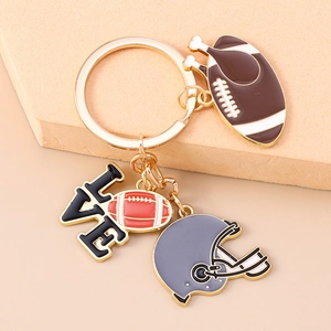 Detail of rugby keychain with helmet, brown football, and Love letter charm in gold plating