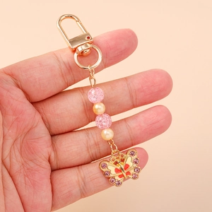 Roze vlinder sleutelhanger met gouden strass hanger en gebarsten kralen