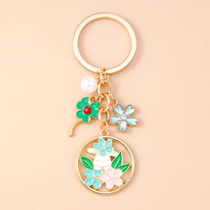 Détail d'un porte-clés doré avec lapin en émail, perle et pendentifs floraux