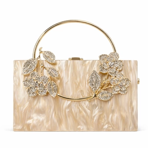 Macro view of crystal floral metal clasp on pearl white acrylic marble clutch bag