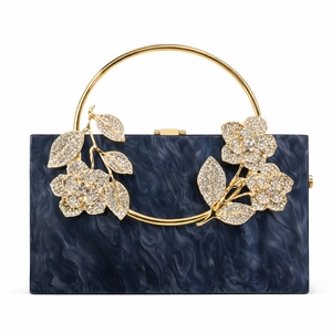 Detail of blue marble acrylic evening bag with gold floral accents and rhinestone petals