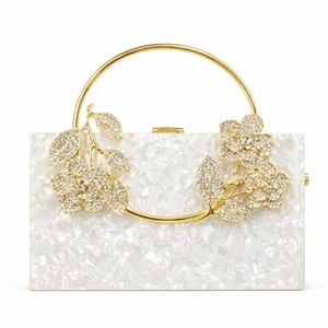 Detailed macro view of white acrylic floral evening clutch with golden ring handle
