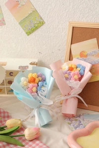 Detail of handmade crochet bouquets with blue and pink yarn flowers and love ribbons