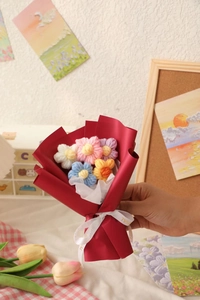 Detailed close-up of handmade crochet flower bouquet in red matte gift wrapping paper