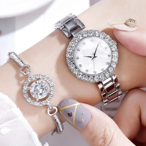 Close-up of diamond-encrusted silver watch and matching bracelet set on a woman's wrist