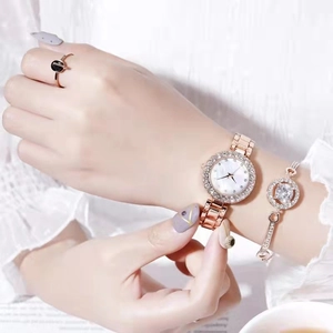 Detail shot of rose gold watch set with crystal-studded bracelet and black gem ring