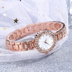 Detail of rose gold watch featuring a diamond bezel and elegant mother of pearl dial