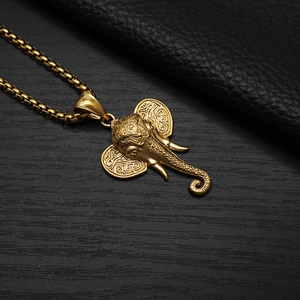 Close-up of a vintage golden Ganesha pendant with intricate carvings and box chain
