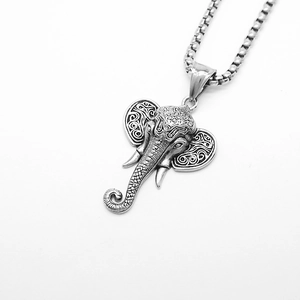 Detailed view of vintage elephant pendant necklace with intricate spiral metal textures