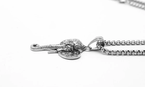 Detailed macro view of vintage elephant pendant with intricate carvings and box chain