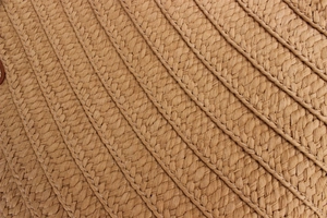 Close-up detail of natural woven straw texture on a large capacity summer shoulder beach bag