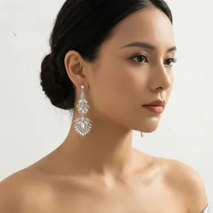 Detailed view of silver wedding earrings with sparkling rhinestones worn by a model