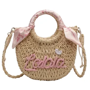 Fashionable semi-circular straw woven handbag with pink silk scarf and Lola embroidery