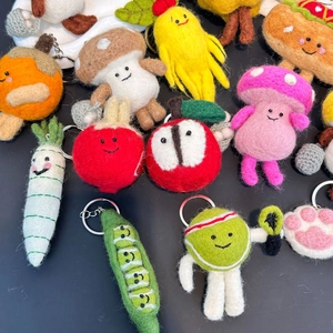 Detailed view of assorted handmade wool felt fruit and vegetable charms with keychains