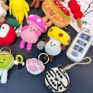 Detailed macro view showing diverse handmade wool felt fruit and veggie keychains