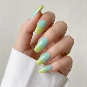 Detail of long coffin press-on nails with shiny green and yellow ombre gradient effect