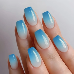 Detail of long coffin press-on nails with blue and white gradient and silver glitter