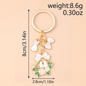 Detail view of pink enamel rabbit and bow keychain with golden finish dimensions shown