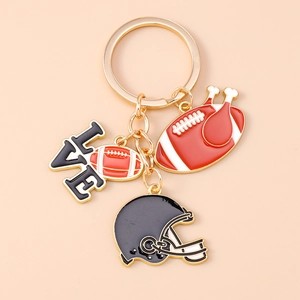 Detail of rugby keychain with black LOVE charm and helmet pendant on gold ring