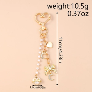 Detailed view of beaded star and rhinestone moon charm with size markings on pink backdrop