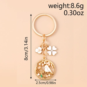 Detail of gold flower keychain with bird pendant showing dimensions and 8.6g weight