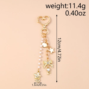 Detail of gold keychain with pearl beads, heart carabiner, and rhinestone bow charm