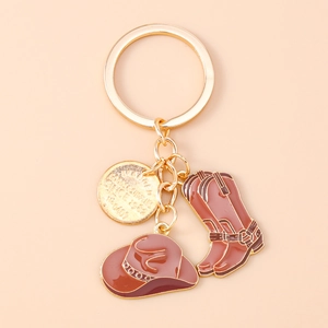 Détail d'un porte-clés de cowboy occidental avec bottes, chapeau et pendentif doré