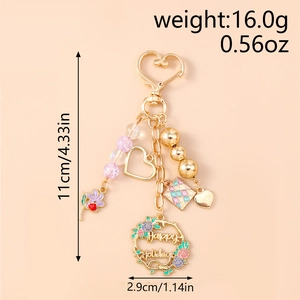 Detail of beaded keychain with Happy Holidays wreath and golden heart pendant