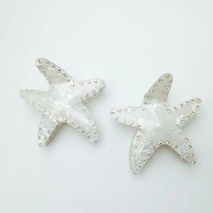 Macro detail of starfish hair clips with iridescent pearl finish and crystal rhinestones