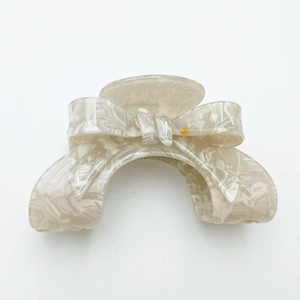 Close-up detail of cream marble texture on a French style ribbon bow hair claw clip