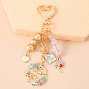 Detailed view of floral holiday charm keychain with golden heart clasp and beads