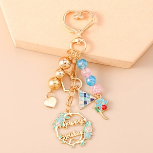 Detailed view of golden flower wreath keychain with Happy Holidays text and heart clasp