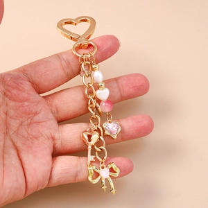 Detail view of heart-shaped key ring with pink gemstone heart and pearl charms