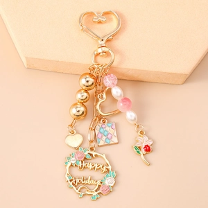 Detailed view of golden heart clasp keychain with colorful beads and flower charms